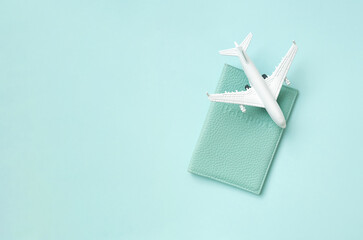 Airplane with passport on the bright sunny blue background. Summer vacation travel concept. Copy space