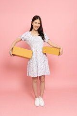 Young Asian woman holding package parcel box isolated on pink background, Delivery courier and shipping service concept - 787348671