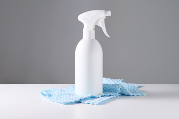 Cleaning product with a sprayer on a background of a blue microfiber cloth.