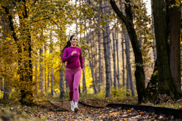 A fit sportswoman is running in nature.