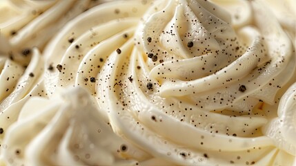 A close-up of the creamy vanilla cream cheese frosting with flecks of black pepper, creating an elegant texture and depth in the background of the recipe.