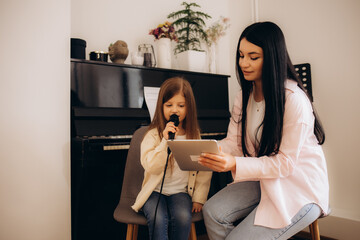 a little girl with a teacher at singing lessons