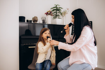 a little girl sings with the teacher at singing lessons
