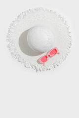 White sun hat and pink colored glasses on white background. Summer vacation, summertime relaxation...