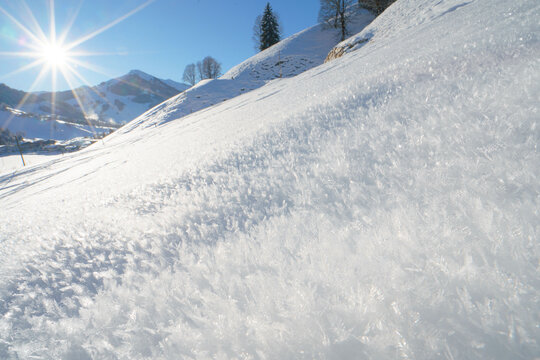 Gefrohrene Eiskristalle auf einer wei&szlig;en Schneeschicht im Winter