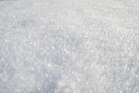 Gefrohrene Eiskristalle auf einer wei&szlig;en Schneeschicht im Winter
