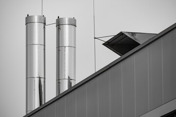 large stainless steel chimneys on the roof of an industrial building