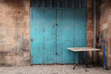 A closed shop facade with a table outside the shop at Akko market during the Ramadan 