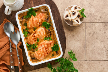 Baked chicken breast bbq with mushrooms and garlic in cream sauce on old brown concrete tilestable backgrounds. Top view image with ingredients for cooking. Top view with copy space.