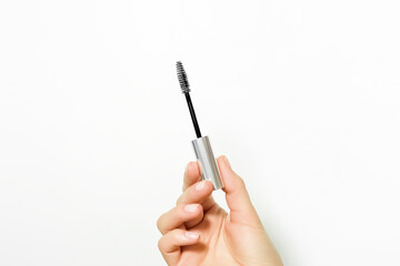 hand holding a brush with eyelash and eyebrow care serum