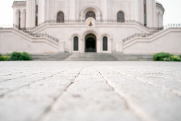 Selective focus. The path along the paving stones to the stairs and blurred doors to the church...