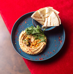 Hummus with olive oil, herbs, chickpeas and pita bread