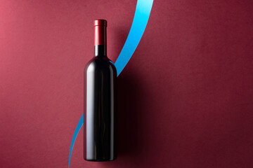 Bottle of red wine on a dark red background.