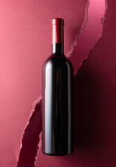 Bottle of red wine on a dark red background.