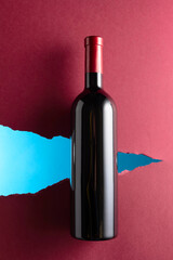 Bottle of red wine on a dark red background. - 787408285