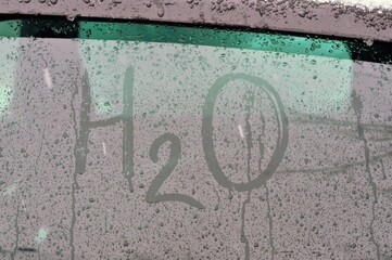 H2O water symbol on car glass in rain