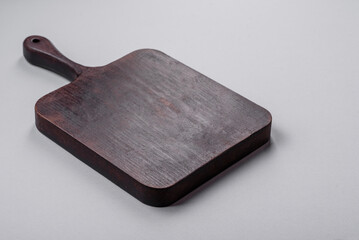 Empty wooden cutting board on gray textured concrete background