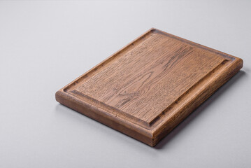 Empty wooden cutting board on gray textured concrete background