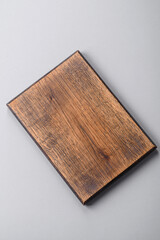 Empty wooden cutting board on gray textured concrete background