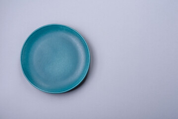 An empty plate on a gray concrete background with copy space