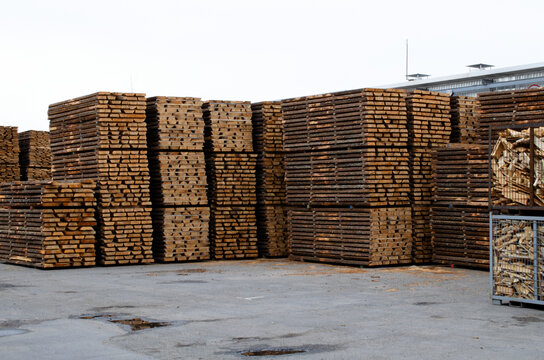 Rough pine lumber stacked at the sawmill. Woodworking plant and sawn timber in stacks for shipment for export. Wooden boards, lumber, commercial timber. Pine timber.
