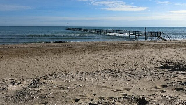 Rimini beach in winter. Italian Adriatico coast. Boat jetty