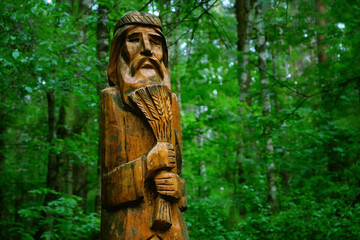 wooden pagan idol in forest, abstract natural background. old god totem in Slavic folk style form...