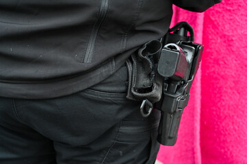 A gun on a policeman's belt. Pistol in the holster of a member of the special police forces. Weapon of police officer. 