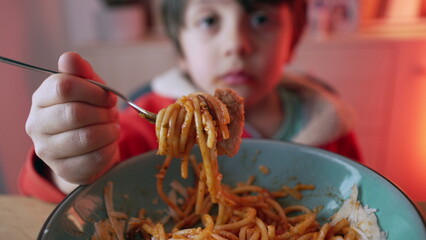 Small boy enjoying plate of pasta for supper, close-up face of 5 year old child eating spaghetti © Marco