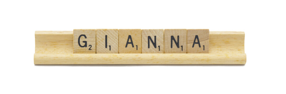 concept of popular newborn baby girl first name of GIANNA made with square wooden tile English alphabet letters with natural color and grain on a wood rack holder isolated on white background