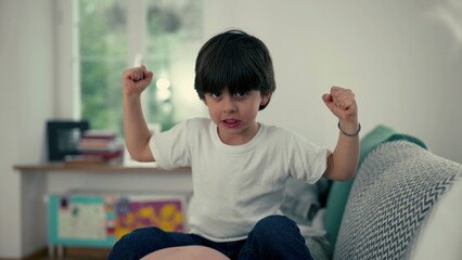 Proud Little Powerhouse - Adorable small Boy Flexing Arms at Home, Showcasing His Growing Strength...