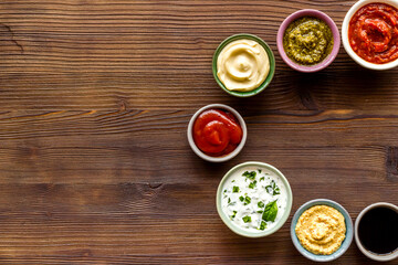 Set of bowls with sauces pesto salsa mustard and others, top view. Food background