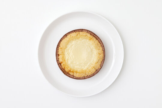 Sweet pie with sour cream at a round plate isolated at white background. Pastry image.