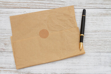 Brown crumpled butcher paper with a pen on weathered wood