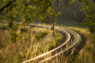 a railway track shining in the rays of the setting sun