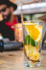 Summer refreshment: crisp water infused with pineapple and orange slices, mint, under the watch of a stylish barman