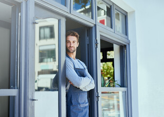 Door, crossed arms and portrait of waiter by coffee shop with positive, happy and confident attitude. Smile, pride and man barista standing by cafe or restaurant entrance for welcome in hospitality.