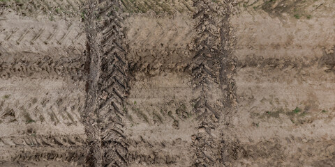 view from above on texture of wet muddy road with tractor tire tracks in countryside - 787461633