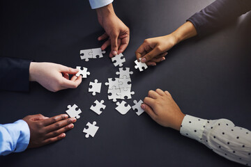 Hands, puzzle and business people with teamwork, planning and brainstorming for project or cooperation. Closeup, staff or group with mission or problem solving with solution, collaboration or synergy