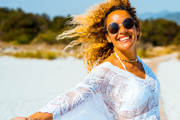 Beautiful woman with white swimsuit cover up on the tropical beach. Portrait of happy blonde woman...