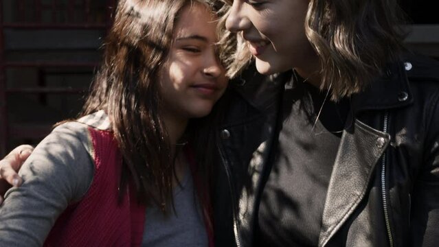 A supportive mother lovingly hugs her daughter