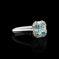 Beautiful white gold ring with diamonds and aquamarine on a black background