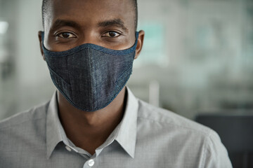 Young African businessman wearing a face mask at work