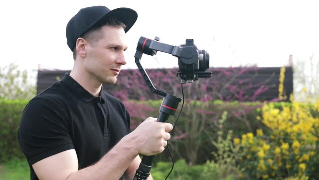 Filmmaker Working outdoors. Digital Video Camera Gimbal Stabilization. DSLR Videography Equipment. 