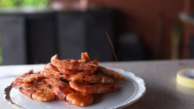 Closeup shot of a plate of barbecued prawns looking spicy and delicious with fresh basil leaves, Panning in Slow Motion