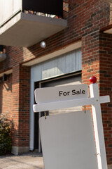 For sale sign in front of a condo house in a residential neighborhood. Copy space for text