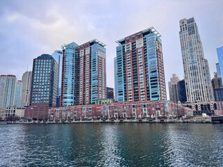 view of old colorful buildings on a bank of the chicago river on a cloudy winter day
