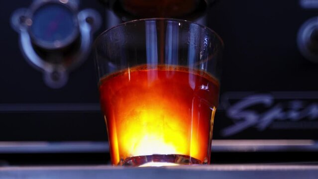close-up of espresso being poured into a glass glass standing on the coffee machine. Coffee classics in coffee shops. Making coffee. High quality 4k footage