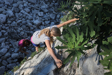 Girl climbing cliff on a bright sunny day