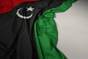 waving national flag of libya on a gray background. - obrazy, fototapety, plakaty
